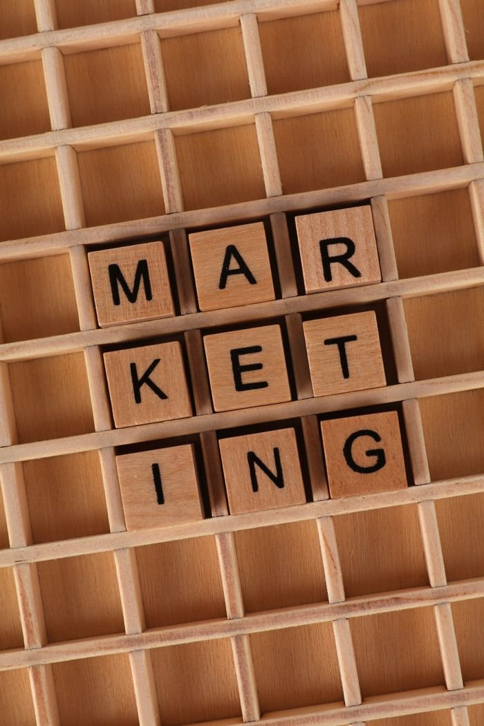 Top view of wooden blocks spelling 'Marketing' on a grid for business themes.