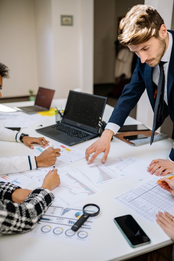 About Business meeting with professionals discussing documents at a workplace desk.